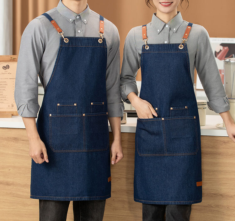 Denim cross back apron N203 with leather patch strap detail and large front pockets for custom B2B workwear orders.